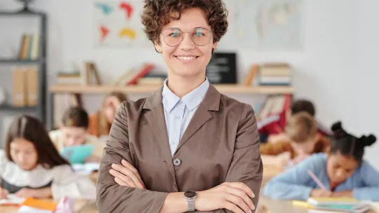habilidades-blandas-profesor una-profesora-posa-con-los-brazos-cruzados-mostrando-habilidades-blandas-como-paciencia-empatía-y-comunicación-en-el-aula