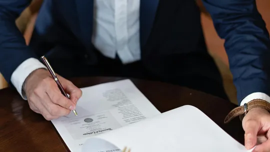 ley-de-patentes hombre-firmando-documento-relacionado-con-la-ley-de-patentes