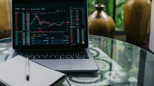 master-en-finanzas-o-mba-online portatil-sobre-mesa-con-graficos-de-inversiones-para-ilustrar-master-en-finanzas-o-mba-online