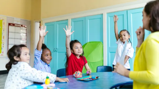 psicologia-educativa-viu grupo-de-ninos-en-clase-levantando-la-mano-para-participar-en-una-sesion-de-psicologia-educativa