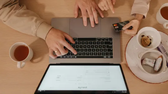 negocios-digitales-en-ecuador personas-realizando-una-transaccion-online-con-tarjeta-de-credito-en-un-ordenador-portatil-ejemplo-de-negocios-digitales-en-ecuador