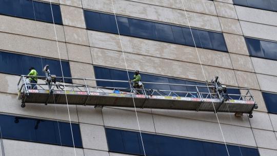 operarios-trabajando-en-un-andamio-de-un-edificio-siguiendo-las-indicaciones-de-un-prevencionista-de-riesgos