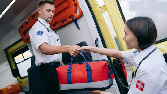 dos-sanitarios-en-una-ambulancia-y-uno-le-esta-dando-una-bolsa-a-otro-realizando-una-buena-labor-de-salud-comunitaria-en-peru