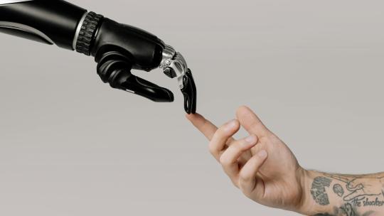 mano-de-hombre-y-mano-de-robot-uniendo-el-indice-como-simbolo-de-los-usos-de-la-inteligencia-artificial-en-la-vida